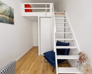a room with a loft bed and a blue chair at Osez Nantes cœur de ville! T3 chic et spacieux in Nantes