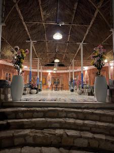 a large room with vases of flowers on a stage at The Sea side camp nuweiba in Nuweiba