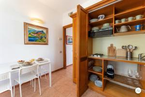 a kitchen and dining room with a table and chairs at Luce di Mare, Vista Mare Sea View in Is Molas  +13 photos