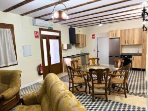 a living room with a table and chairs and a kitchen at Hotel A Posada in Tembleque