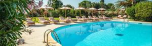 a swimming pool with lounge chairs and umbrellas at Luce di Mare, Vista Mare Sea View in Is Molas 