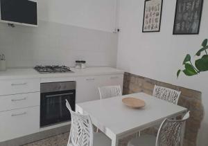 a kitchen with a table and a stove and a table and chairs at Il Verde Rifugio in San Lorenzo