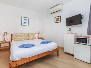a bedroom with a bed and a tv on a wall at Apartment Mestral Atic by Interhome in Tossa de Mar