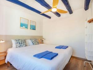 a bedroom with a white bed with a ceiling fan at Apartment Mestral Atic by Interhome in Tossa de Mar
