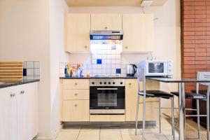 a kitchen with a stove and a microwave at Isiphephelo Property in Johannesburg +3 photos