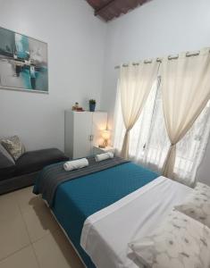 a bedroom with a bed and a window with curtains at Mini Bamboo Nest con Desayuno in Puyo