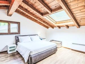 a bedroom with a large bed and a wooden ceiling at Apartment Borgo Castello-4 by Interhome in Argegno