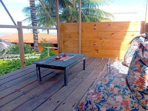 a wooden deck with a coffee table and a couch at Pousada Kite Guajiru in Itarema