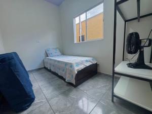 a small bedroom with a bed and a window at Casa Grande e Climatizada in Campo Grande