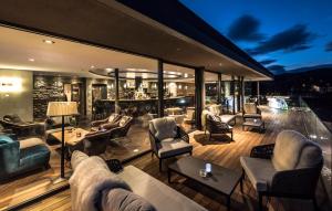 a living room with couches and chairs on a deck at LeFie in Vols am Schlern