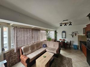 a living room with a couch and a table at Nearby PORTONOVI-Norwegian-village DUPLEX in Đenovići
