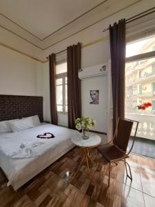 a bedroom with a bed and a table and a chair at Dawn town palace in Cairo
