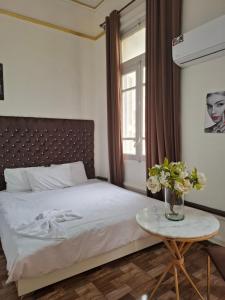 a bedroom with a bed and a table with flowers at Dawn town palace in Cairo +22 photos