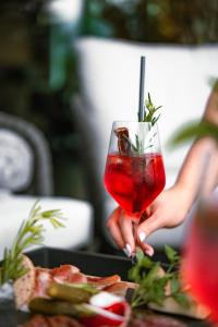 a person holding a red drink in a glass at LeFie in Vols am Schlern +10 photos