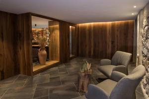 a lobby with two chairs and a vase at LeFie in Vols am Schlern
