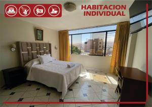 a hotel room with a bed and a large window at Hotel Palmeras Tacna in Tacna +4 photos