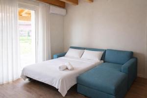 a bedroom with a bed and a blue couch at Villa Alberti - Elegant, Spacious & Bright Villa in Casa Reali