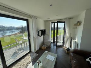a living room with a couch and a large sliding glass door at Lakeside Apartment in Enniskillen