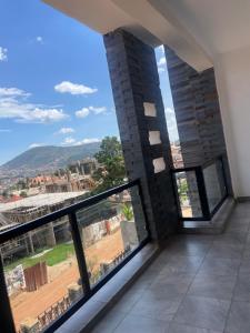 a room with a large window with a view of a field at Kigali Legacy Villa Homes in Kigali