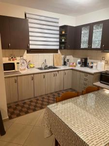 a kitchen with wooden cabinets and a table and a microwave at The root loft Trikala in Tríkala