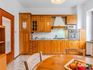 a kitchen with wooden cabinets and a table with fruit on it at Apartment Onda Blu by Interhome in Gera Lario