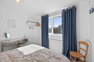 a bedroom with a bed and a chair and a window at 2 Bed in Seahouses oc-86092 in North Sunderland