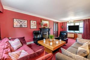 a living room with red walls and a couch and a table at 4 Bed in Helmsley oc-y039 in Helmsley