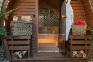 a wooden sauna with a door and two baskets at The Old Mill House Experience in Dalkeith