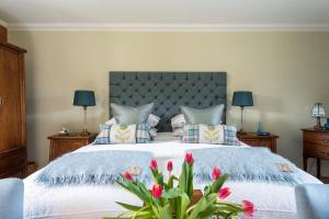 a bedroom with a large bed with red tulips at The Old Mill House Experience in Dalkeith