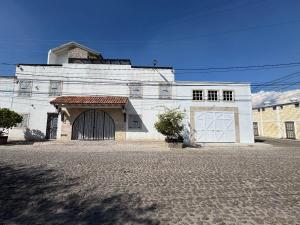 a white building with two garage doors on a street at Casa Martha hotel boutique in Tequisquiapan