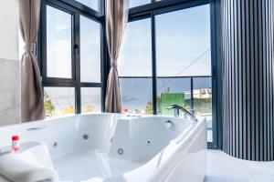 eine Badewanne in einem Badezimmer mit einem großen Fenster in der Unterkunft Sapanora Hotel in Sapanca + 30 Fotos