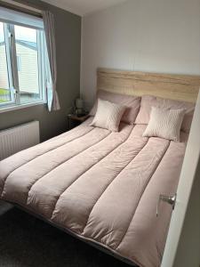 a large bed in a bedroom with a window at Shivvys at sandylands in Stevenston
