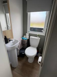 a bathroom with a toilet and a sink and a window at Shivvys at sandylands in Stevenston +31 photos