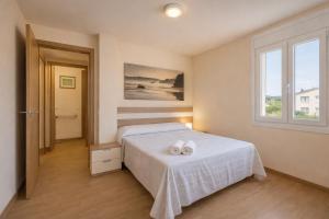 a bedroom with a bed with two white towels on it at Nova MSuites Catedrales in Foz