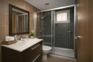 a bathroom with a toilet and a sink and a shower at Nova MSuites Catedrales in Foz