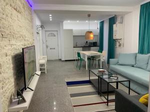a living room with a blue couch and a table at PP Apartments Deluxe in Năvodari