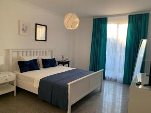 a bedroom with a large bed with blue pillows at PP Apartments Deluxe in Năvodari
