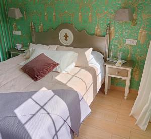 a bedroom with two beds with green wallpaper at Alojamiento Playa de Candás in Candás
