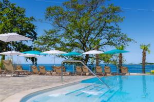 a swimming pool with chairs and umbrellas at SUNNY Mobile Homes Bijela Uvala in Poreč