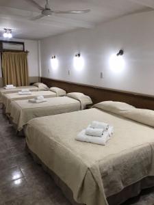 a room with four beds with towels on them at Hotel Avenida in General Alvear +44 photos