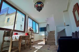 a room with a table and chairs and windows at CASA ADiL in Tangier +39 photos