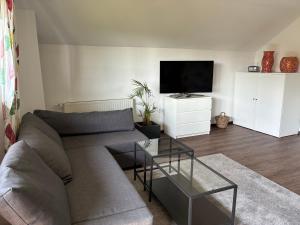 a living room with a couch and a flat screen tv at Ferienwohnung Kolb in Issum
