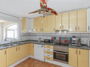 a kitchen with wooden cabinets and a ceiling fan at Holiday Home Floramar by Interhome in Lloret de Mar