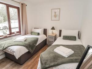 a bedroom with two beds and a window at Willows Lodge at Carreg Llwyd in Cardiff