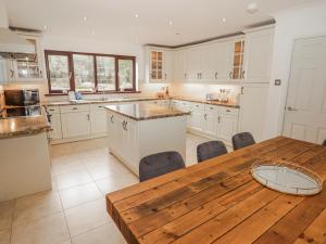 a large kitchen with a wooden table and a wooden table sidx sidx sidx at Willows Lodge at Carreg Llwyd in Cardiff