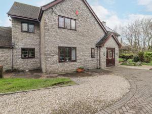 a brick house with a driveway in front of it at Willows Lodge at Carreg Llwyd in Cardiff