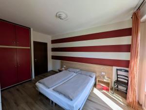 a bedroom with a bed and a striped wall at Ristorante Le Rasole in Garda +23 photos