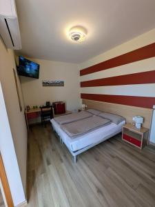 a bedroom with a bed with a red and white stripes at Ristorante Le Rasole in Garda