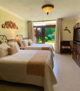 a hotel room with two beds and a television at Hostal Villa Toscana in Guatemala