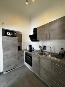 a kitchen with stainless steel cabinets and a sink at Gästehaus Flair in Mettlach